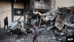 26 Aralık 2024 - Bir çocuk, saldırıya uğrayan yayın aracının enkazının yanından yürüyor.
