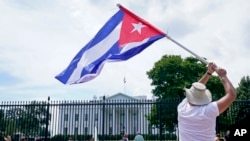 Un manifestante ondea una bandera cubana frente a la Casa Blanca. [Archivo/AP]