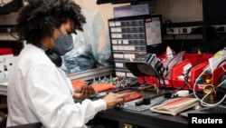 Un empleado ensambla manualmente un elemento de placa de circuito antes de una ceremonia de corte de cinta para marcar la apertura de un centro de fabricación de nanotrónicos en Brooklyn Navy Yard, en el distrito de Brooklyn de Nueva York, EE.UU., 28 de a