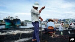 As Typhoon Soudelor approaches, fishermen make use of time in port to repair nets in Yilan County, northeastern Taiwan, Thursday, Aug. 6, 2015. 