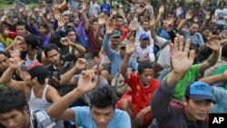 Rescued Burmese fishermen raise their hands as they are asked who among them wants to go home at the compound of Pusaka Benjina Resources fishing company in Benjina, Aru Islands, Indonesia. The men are from several countries. Picture from 2015.