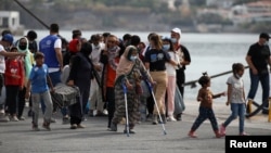 Arhiva - Izbeglice i migranti iz uništenog kampa Morija čekaju da se ukrcaju u trajekt kojo će ih prebaciti do kopna, u luci Mitlien na ostrvu Lezbos, Grčka, 28. septembra 2020.