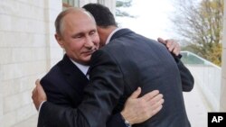 ARHIVA: Ruski predsjednik Vladimir Putin grli se sa sirijskim predsjednikom Bašarom al-Asadom tokom susreta u Sočiju, 21. novembar 2017. godina (Foto: Mikhail Klimentyev, Kremlin Pool Photo via AP)