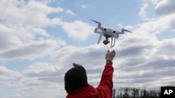 FILE - A drone operator helps to retrieve a drone after photographing over Hart Island in New York on April 29, 2018. Federal, state and local officials met on Dec. 11, 2024, to discuss a number of mysterious drone sightings in the neighboring state of New Jersey.