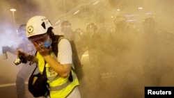 在香港警察向反送中示威者發射催淚彈後一名記者用手掩住口鼻。 （2019年8月4日）