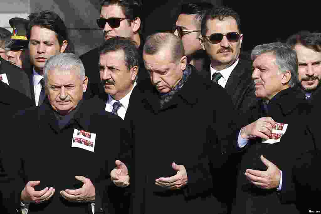 Turkish Prime Minister Binali Yildirim, President Tayyip Erdogan and former President Abdullah Gul pray during a ceremony for police officers killed in Saturday's blasts in Istanbul, Dec. 11, 2016.