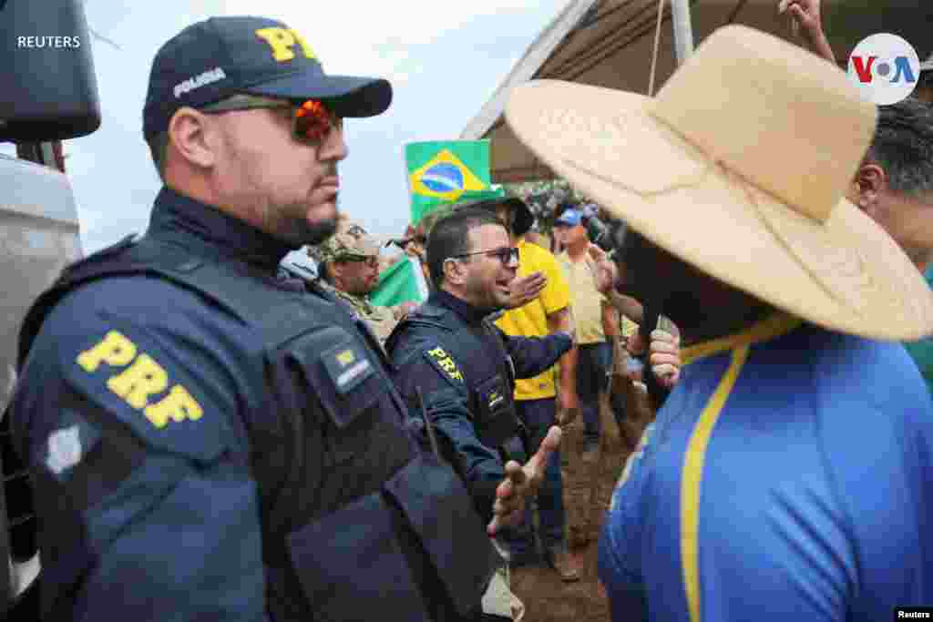 Agentes de la Policía Federal de Carreteras hacen guardia, mientras comienzan a desbloquear la carretera BR-251, durante una protesta de los partidarios del presidente de Brasil, Jair Bolsonaro, contra el presidente electo, Luiz Inácio Lula da Silva, que ganó un tercer mandato tras la segunda vuelta de las elecciones presidenciales, en Planaltina, Brasil, el 1 de noviembre de 2022.&nbsp;