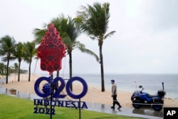 Seorang polisi berjalan melewati tanda G20 di Nusa Dua, Bali, Kamis, 7 Juli 2022. (Foto: AFP)