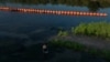 Un contrabandista, usualmente llamado 'coyote', pasa junto a boyas desplegadas para disuadir a los migrantes en el río Grande entre Estados Unidos y México, en Eagle Pass, Texas, EEUU, el 14 de septiembre de 2023.