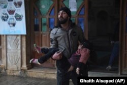 A Syrian man carries a dead young girl, in Azmarin town, in Idlib province north Syria, Monday, Feb. 6, 2023. (AP Photo/Ghaith Alsayed)