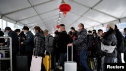 ប្រជាជន​កាន់​វ៉ាលី​ដាក់​ឥវ៉ាន់​របស់​ខ្លួន​នៅ​ស្ថានីយ​រថភ្លើង​មួយ​ក្នុង​អំឡុងដែល​ពិធី​បុណ្យ​ចូល​ឆ្នាំ​ចិន​ជិត​ចូល​មក​ដល់ ខណៈ​ពេល​ដែល​ជំងឺ​កូវីដ​១៩​កំពុង​ផ្ទុះ​ឆ្លង នៅ​ទីក្រុង​សៀងហៃ ប្រទេស​ចិន ថ្ងៃទី ១៦ ខែមករា ឆ្នាំ២០២៣។ 