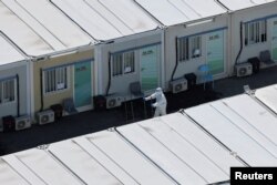 A worker wears personal protective equipment at a COVID-19 isolation facility in Tsing Yi, during the COVID-19 pandemic in Hong Kong, China, March 8, 2022.