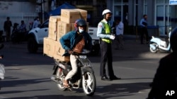 រូបឯកសារ៖ បុរសម្នាក់ដឹកទំនិញតាមម៉ូតូជូនអតិថិជន នៅរាជធានី​ភ្នំពេញ ថ្ងៃទី ១៩ ខែមករា ឆ្នាំ ២០២២។