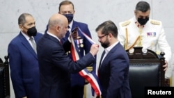 El recién juramentado presidente de Chile, Gabriel Boric, recibe la faja del presidente del Senado, Álvaro Elizalde, en el Congreso de Valparaíso, Chile, el 11 de marzo de 2022.