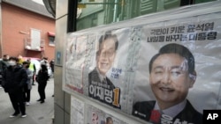 Posters of presidential candidates of Lee Jae-myung of the ruling Democratic Party and Yoon Suk Yeol, right, of the main opposition People Power Party are displayed at a local polling station in Seoul, South Korea, Friday, March 4, 2022. (AP Photo/Ahn Young-joon)