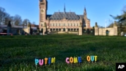 ទៀន​ត្រូវ​គេ​ដាក់​នៅ​លើ​ស្មៅ​ដោយ​មាន​សរសេរ​ថា «លោក Putin ចេញ​មក» នៅ​មុខ​តុលាការ​ឧក្រិដ្ឋកម្ម​អន្តរជាតិ​ក្នុង​ទី​ក្រុង​ឡាអេ​ប្រទេស​ហូឡង់ កាល​ពី​ថ្ងៃ​ច័ន្ទ​ទី​៧ ខែ​មីនា ឆ្នាំ​២០២២។