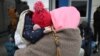 Una madre ucraniana sostiene a su hijo mientras espera en un puesto de control para ingresar a Rumania, después de cruzar el río Danubio en el cruce fronterizo de Isaccea-Orlivka entre Rumania y Ucrania el 26 de febrero de 2022.