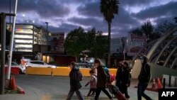 Ciudadanos ucranianos caminan junto con activistas en el lado mexicano de la frontera después de que las autoridades de Aduanas y Protección Fronteriza les negaron el ingreso a los Estados Unidos bajo el Título 42, en el puerto de cruce de San Ysidro, el 9 de marzo 2022.