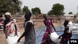 Watu waliolazimika kuhama makazi yao wakiwa mjini Bor, Sudan Kusini wakipokea msaada mwezi uliopita. (Kate Bartlett/VOA)