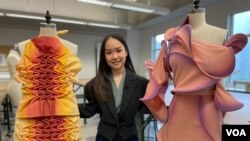 Illene Martoseno berpose dengan dua rancangannya untuk kompetisi desain Supima pada 2019 (VOA Maret 2022)