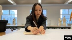 Illene Martoseno sedang membuat pola busana (VOA)