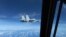 In this image taken from a Dec. 21, 2022, video, a Chinese Navy J-11 fighter jet flies close to a U.S. Air Force RC-135 aircraft in international airspace over the South China Sea, according to the U.S. military. (Image from U.S. Indo-Pacific Command/Handout via Reuters)