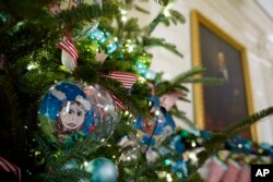 Ornaments containing self-portraits of students from across the country hang from a tree in the State Dining Room of the White House during a press preview of holiday decorations at the White House, Monday, Nov. 28, 2022, in Washington. (AP Photo/Patrick Semansky)