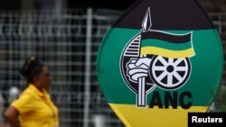 Mwanachama wa chama cha African national congress akiwa amesisimama karibu na picha inayoonyesha nembo ya chama hicho wakati wa kongamano la 55 la chana, mjini Johannesburg, Afrika kusini, Dec. 18, 2022.