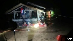 This handout photo taken on Dec. 25, 2022 and received on Dec. 26 from the Philippine Coast Guard shows rescuers evacuating people from a flooded area in Ozamiz City, Misamis Occidental.