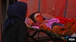 Ayu Rahayu sedang menemani anaknya, Nur Alika (kanan) yang mengalami lula di kepala dan pelipis matanya dirawat di RSUD Sayang pasca gempa berkekuatan 5.6 magnitudo mengguncang Cianjur pada Senin (21/11) siang. (VOA/Indra Yoga)