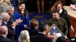 Ukrainian President Volodymyr Zelenskyy holds an American flag that was gifted to him by House Speaker Nancy Pelosi of Calif., as he leaves after addressing a joint meeting of Congress on Capitol Hill in Washington, Dec. 21, 2022. 