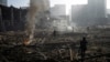 FILE - People survey the destruction amid the smoldering remains of a shopping center in Kyiv, Ukraine, following a shelling by Russian forces on March 21, 2022.