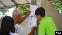 រូបឯកសារ៖ បុរសម្នាក់ផ្ទៀងផ្ទាត់ឈ្មោះនៅក្នុងបញ្ជីឈ្មោះអ្នកបោះឆ្នោត មួយថ្ងៃមុនថ្ងៃបោះឆ្នោតឃុំសង្កាត់អាណត្តិទី ៥ នៅសង្កាត់ផ្សារកណ្តាលទី ១ ខណ្ឌដូនពេញ រាជធានីភ្នំពេញ ថ្ងៃសៅរ៍ ទី ៤ ខែមិថុនា ឆ្នាំ ២០២២។ (ខាន់ សុគុំមនោ/វីអូអេ)