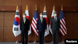 Kim Gunn, South Korea's new special representative for Korean Peninsula peace and security affairs, his U.S. counterpart Sung Kim and Japanese counterpart Takehiro Funakoshi pose for photographs before their meeting at the Foreign Ministry in Seoul, South Korea, June 3, 2022. 