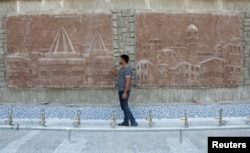 The sculptor Khaled al-Abadi looks at sculptures he completed which depict scenes from the history of the city of Mosul, in Mosul, Iraq, September 15, 2022. (REUTERS/Khalid al-Mousily)