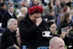 A woman reacts in Hyde Park while watching the State Funeral Service of Britain's Queen Elizabeth II on giant screens, Monday, Sept. 19, 2022 in London. (AP Photo/Lewis Joly)