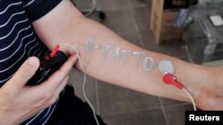 Steve Park, Materials Science & Engineering professor at Korea Advanced Institute of Science and Technology (KAIST), demonstrates an electronic tattoo on his arm connected with an electrocardiogram monitoring system in Daejeon, South Korea, July 26, 2022. (REUTERS/Minwoo Park)