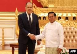 A handout picture taken and released by the Russian Foreign Ministry press service on August 3, 2022, shows Russian Foreign Minister Sergei Lavrov (R) shaking hands with Myanmar Min Aung Hlaing, Senior General and Chairman of the State Administration Council in Naypyidaw. (Photo by HANDOUT / RUSSIAN FOREIGN MINISTRY / AFP)