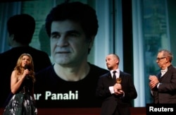 FILE - Jury president Darren Aronofsky, center, holds the Golden Bear for Best Film for the film "Taxi" by Jafar Panahi at the Berlinale International Film Festival on Feb. 14, 2015. Panahi was not at the ceremony because he was not allowed to leave Iran.