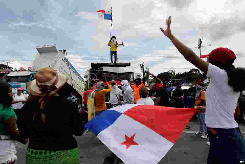 Un hombre ondea una bandera panameña encima de un camión mientras la carretera Panamericana permanece bloqueada en Chame, Panamá, el 14 de julio de 2022.