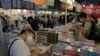 Visitors read at a booth during the annual book fair in Hong Kong, Wednesday, July 20, 2022. 
