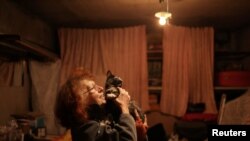 Natalia Pasternak (68) memegang salah satu kucing yang ditinggalkan oleh keluarga yang melarikan diri dari perang di lingkungannya di Saltivka utara, Kharkiv, Ukraina 18 Juli 2022. (REUTERS/Nacho Doce)