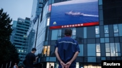 បុរស​ម្នាក់​​ទស្សនា​ការ​ផ្សាយ​ព័ត៌មាន​ពី​ទូរទស្សន៍​រដ្ឋ​ចិនCCTV អំពី​សមយុទ្ធ​យោធា​របស់​កងទ័ព​រំដោះ​ប្រជាជន​ចិន (PLA) នៅ​ផ្សារ​ទំនើប​មួយ​កន្លែង​នៅ​ក្នុង​ទី​ក្រុង​ប៉េកាំង​ ប្រទេស​ចិន​ កាល​ពី​ថ្ងៃ​ទី​៣ ខែ​សីហា ឆ្នាំ​២០២២។