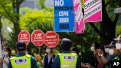 Demonstranti drže transparente protiv sankcija Severnoj Koreji, saveza SAD, Južne Koreje i Japana i politike odvraćanja tokom mitinga ispred Ministarstva spoljnih poslova u kom se sastaju predstavnici SAD, Južne Koreje i Japana, u Seulu, Južna Koreja, 3. juna 2022.