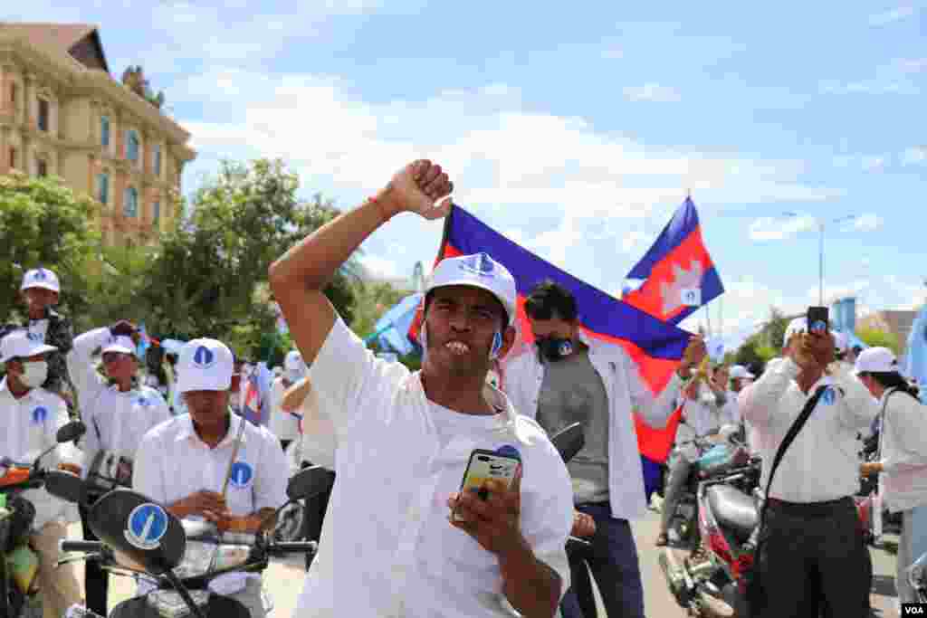 អ្នកគាំទ្រគណបក្សភ្លើងទៀនម្នាក់លើកដៃ ខណៈពេលចូលរួមហែក្បួននៃយុទ្ធនាការឃោសនាបោះឆ្នោតឃុំសង្កាត់អាណត្តិទី ៥ នៅខេត្តសៀមរាប ថ្ងៃទី ៣ ខែមិថុនា ឆ្នាំ ២០២២។ (លាស់ លីបលីប/វីអូអេ)