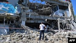 Muškarac gleda u supermarket koji je djelimično uništen u raketnom napadu na periferiji ukrajinskog grada Harkova 8. juna 2022. godine, usred ruske invazije na Ukrajinu. 