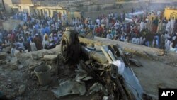 Des badauds autour des restes d'un avion de ligne nigérian tombé dans un quartier résidentiel bondé de Kano, le 5 mai 2002.