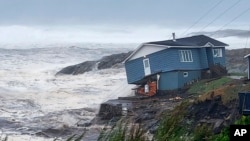 In this photo provided by Wreckhouse Press, a home is hit with high winds caused by post Tropical Storm Fiona in Port aux Basques, Newfoundland and Labrador, Sept. 24, 2022. The home has since been lost at sea.