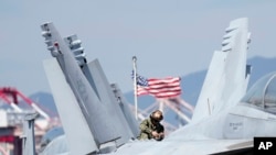 U.S. soldier checks the F/A-18 Super Hornet fighter jet on the deck of the nuclear-powered aircraft carrier USS Ronald Reagan in Busan, South Korea, Sept. 23, 2022. The nuclear-powered aircraft carrier USS Ronald Reagan arrived in the South Korean port of
