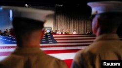 FILE - Army members hold the U.S. flag as they attend an annual Memorial Day ceremony at the Intrepid Museum in New York, May 29, 2017.